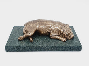 A sculpture of an English Bulldog sleeping on a Lakeland slate base