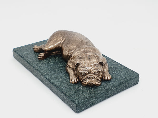 A sculpture of an English Bulldog sleeping on a Lakeland slate base