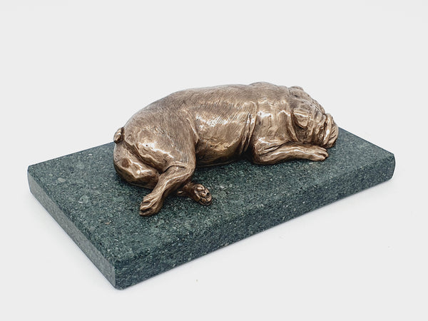 A sculpture of an English Bulldog sleeping on a Lakeland slate base