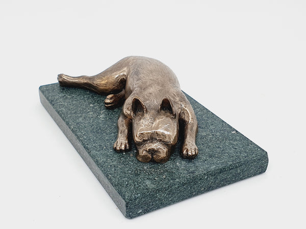 A sculpture of a sleeping Boston Terrier in bronze on a Lakeland slate base