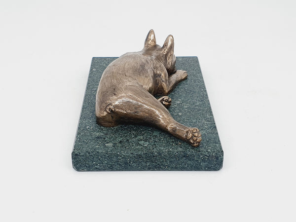 A sculpture of a sleeping Boston Terrier in bronze on a Lakeland slate base