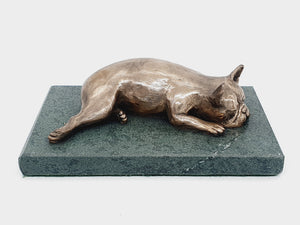 A sculpture of a French Bulldog sleeping on a Lakeland sate base