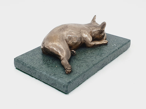 A sculpture of a French Bulldog sleeping on a Lakeland sate base