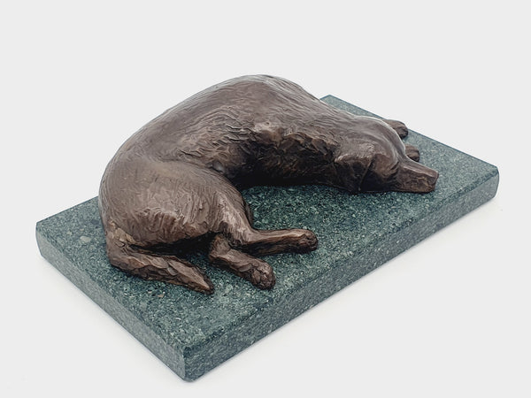 A bronze sculpture of a Golden Retriever sleeping  on a Lakeland Slate base