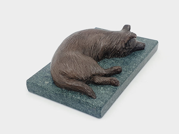 A bronze sculpture of a Border Collie on a Lakeland slate base