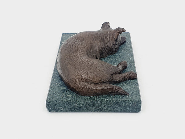 A bronze sculpture of a Border Collie on a Lakeland slate base