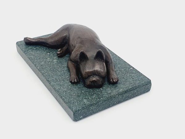 A sculpture of a sleeping Boston Terrier in bronze on a Lakeland slate base