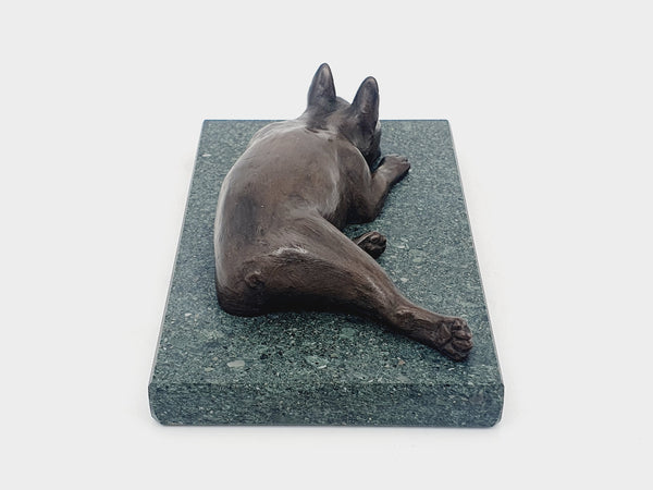 A sculpture of a sleeping Boston Terrier in bronze on a Lakeland slate base