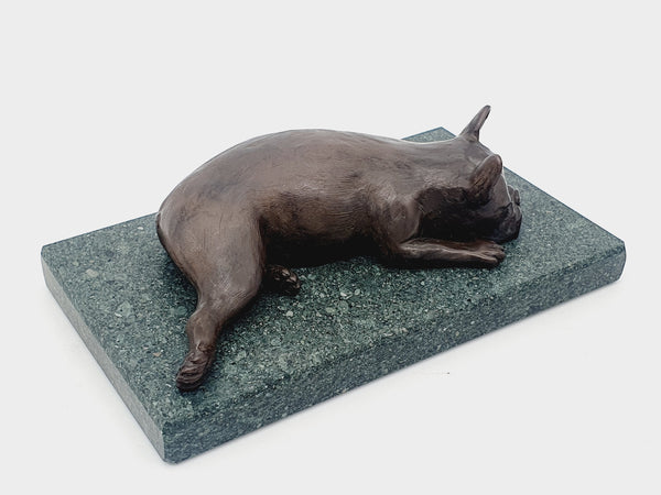 A sculpture of a French Bulldog sleeping on a Lakeland sate base