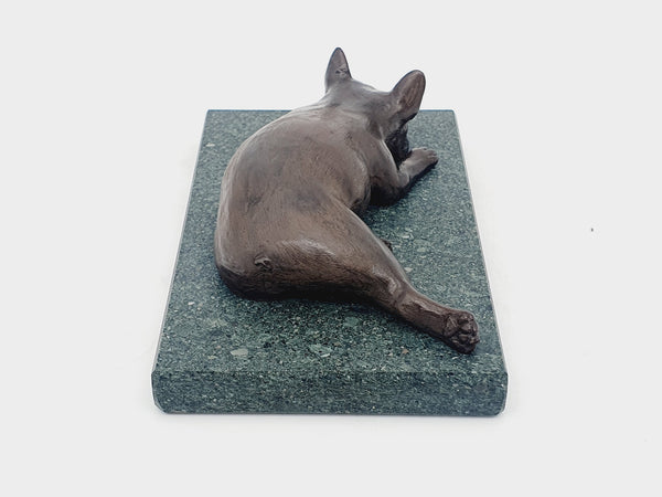 A sculpture of a French Bulldog sleeping on a Lakeland sate base